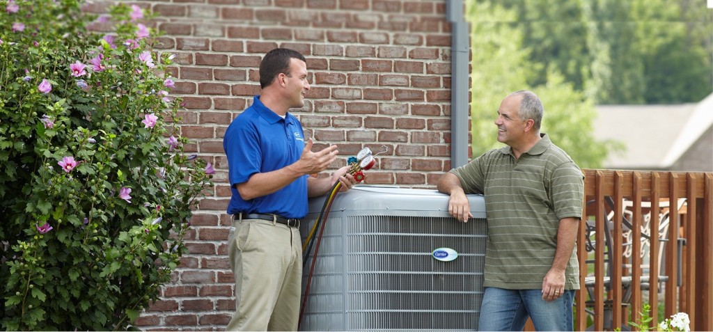 Technician consulting with a male resident about his HVAC unit in Farmington Hills