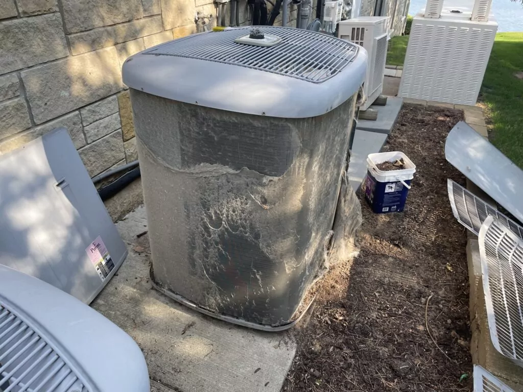 A dirty outdoor AC unit before cleaning and maintenance